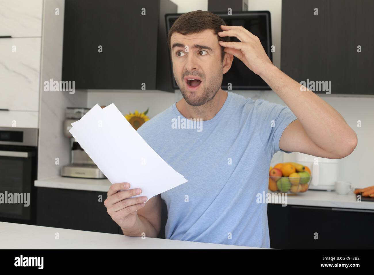 Stressed out man looking documents in the kitchen Stock Photo