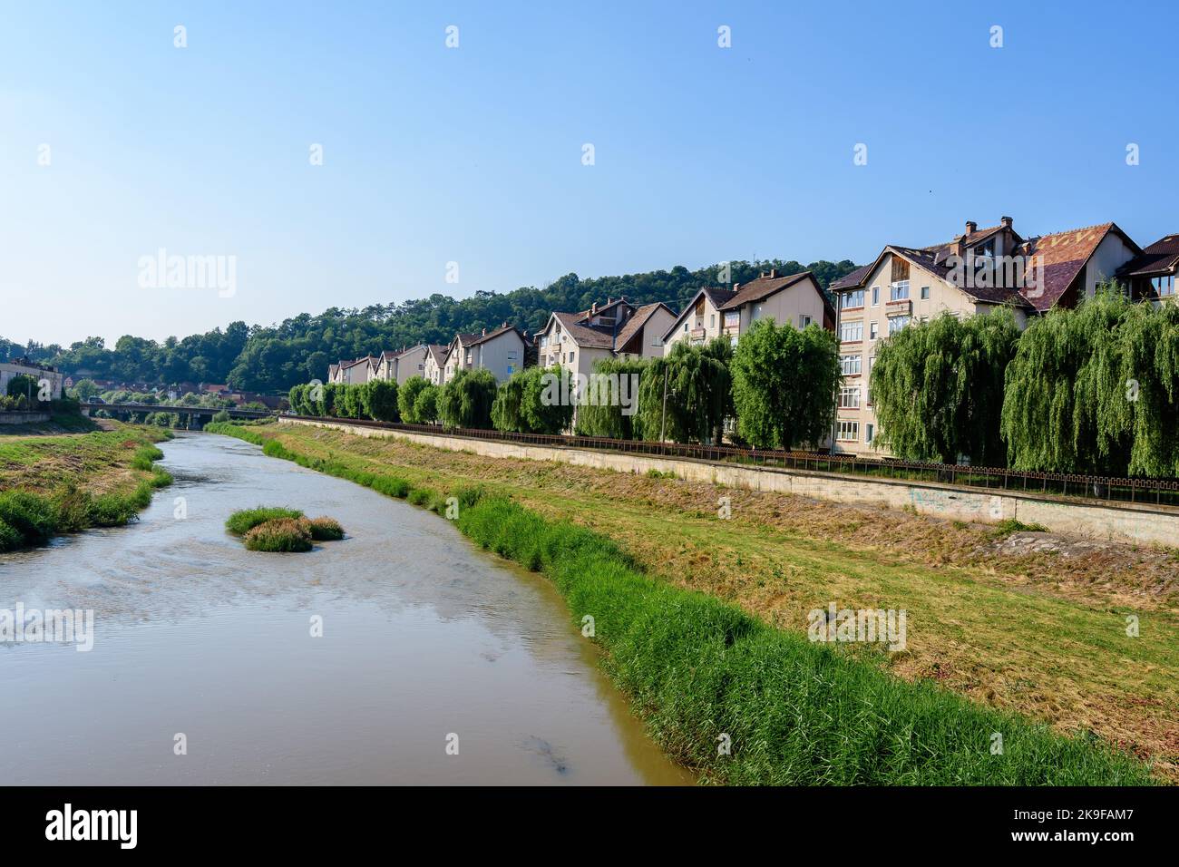 City landscape with Tarnava Mare River and blocks of flats in the center of Sighisoara, in Transylvania (Transilvania) region, Romania, in a sunny sum Stock Photo