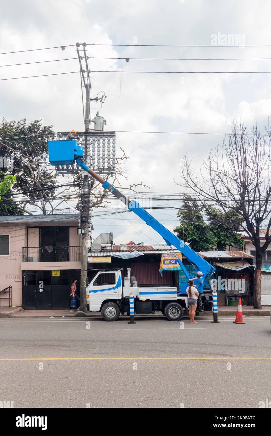 A boom truck of an electric utility company servicing an electric pole