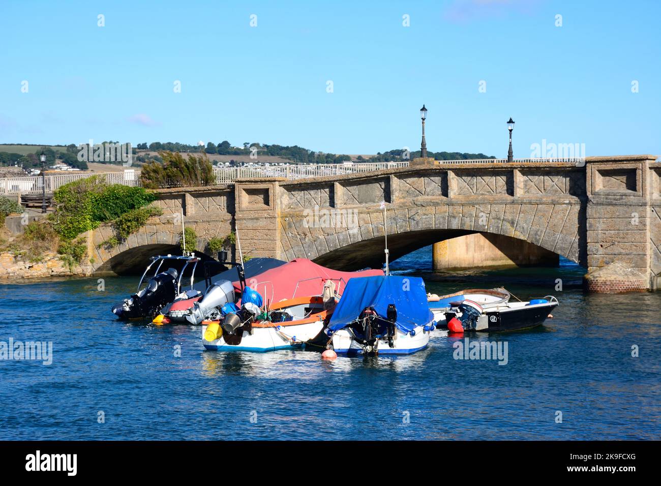 Bridge across the River Axe with small boats in the foreground, Axmouth, Devon, UK, Europe. Stock Photo
