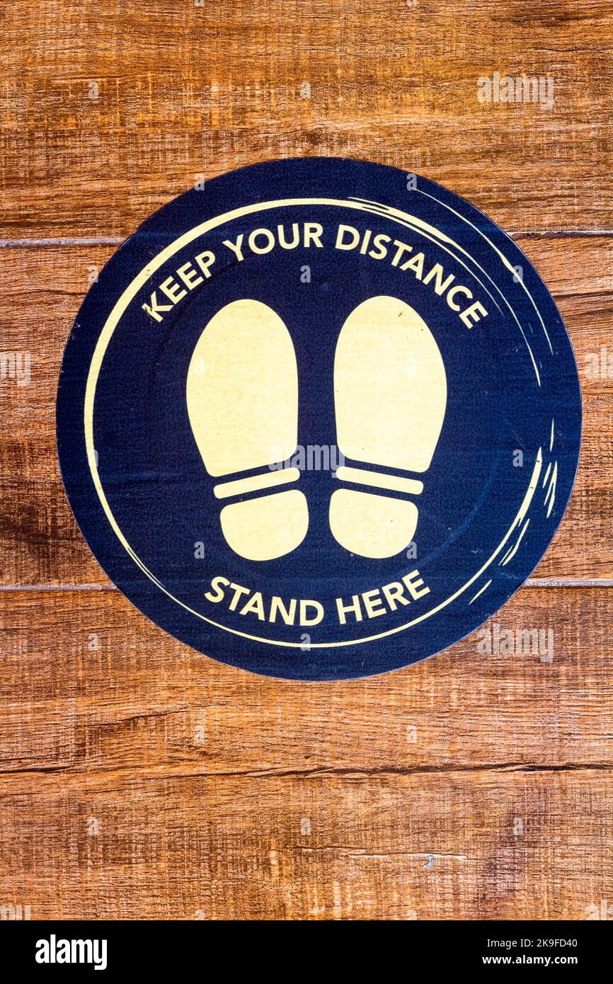 A 'Keep your distance, stand here' sign at a cafe in Cebu City, Philippines Stock Photo