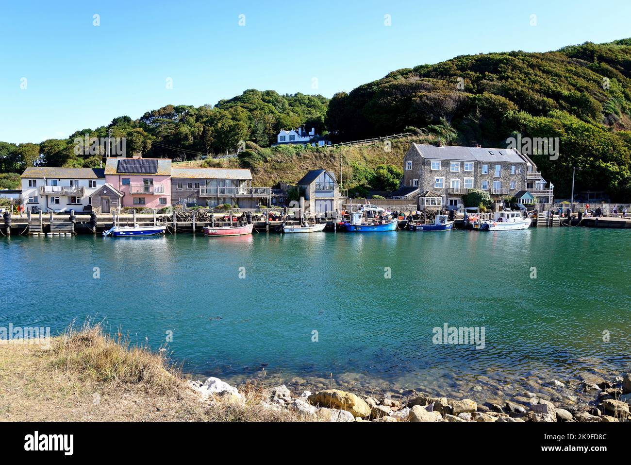 Fishing boats moored alongside the waterfront with buildings to the rear, Axmouth, Devon, UK, Europe. Stock Photo