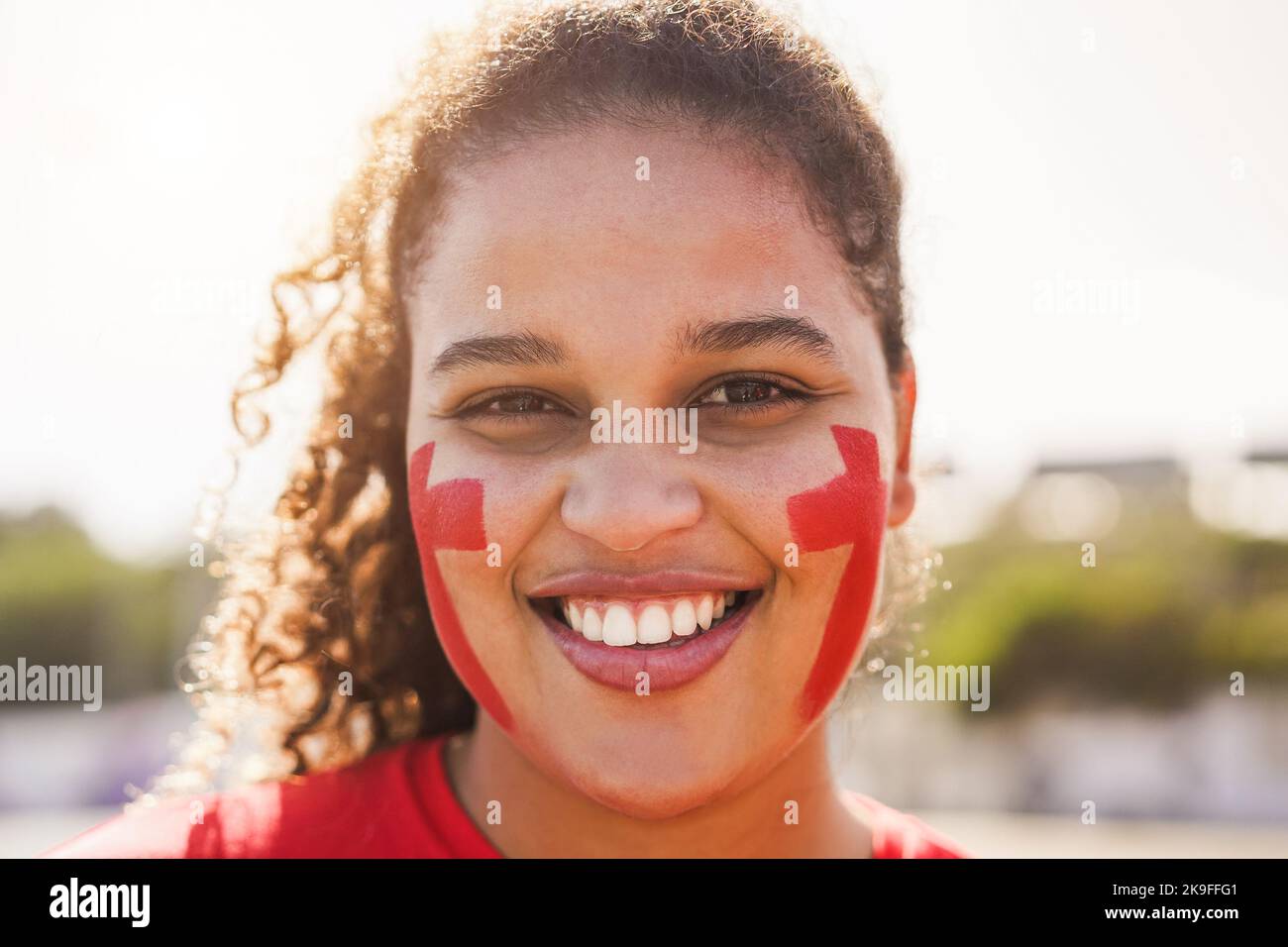 Red sport fan looking on camera out of the stadium before football match - Focus on face Stock Photo