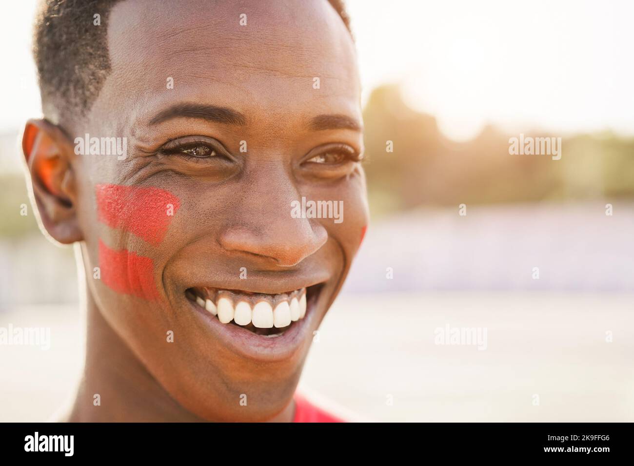 Red sport fan having fun out of the stadium before football match - Main focus on left eye Stock Photo
