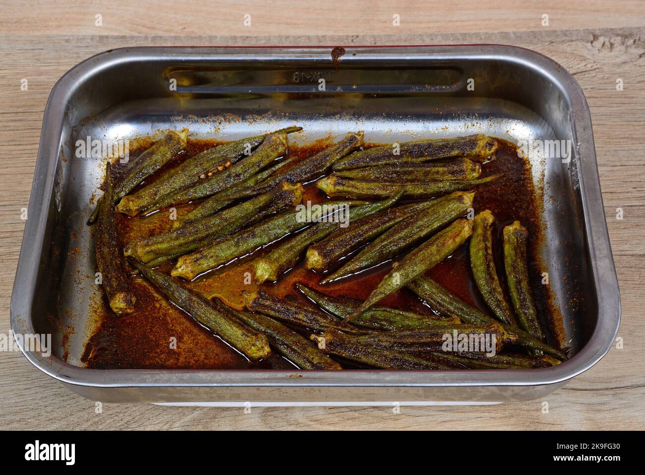 Spicy oven roasted okra in a stainless steel roasting dish, England, UK, Western Europe Stock