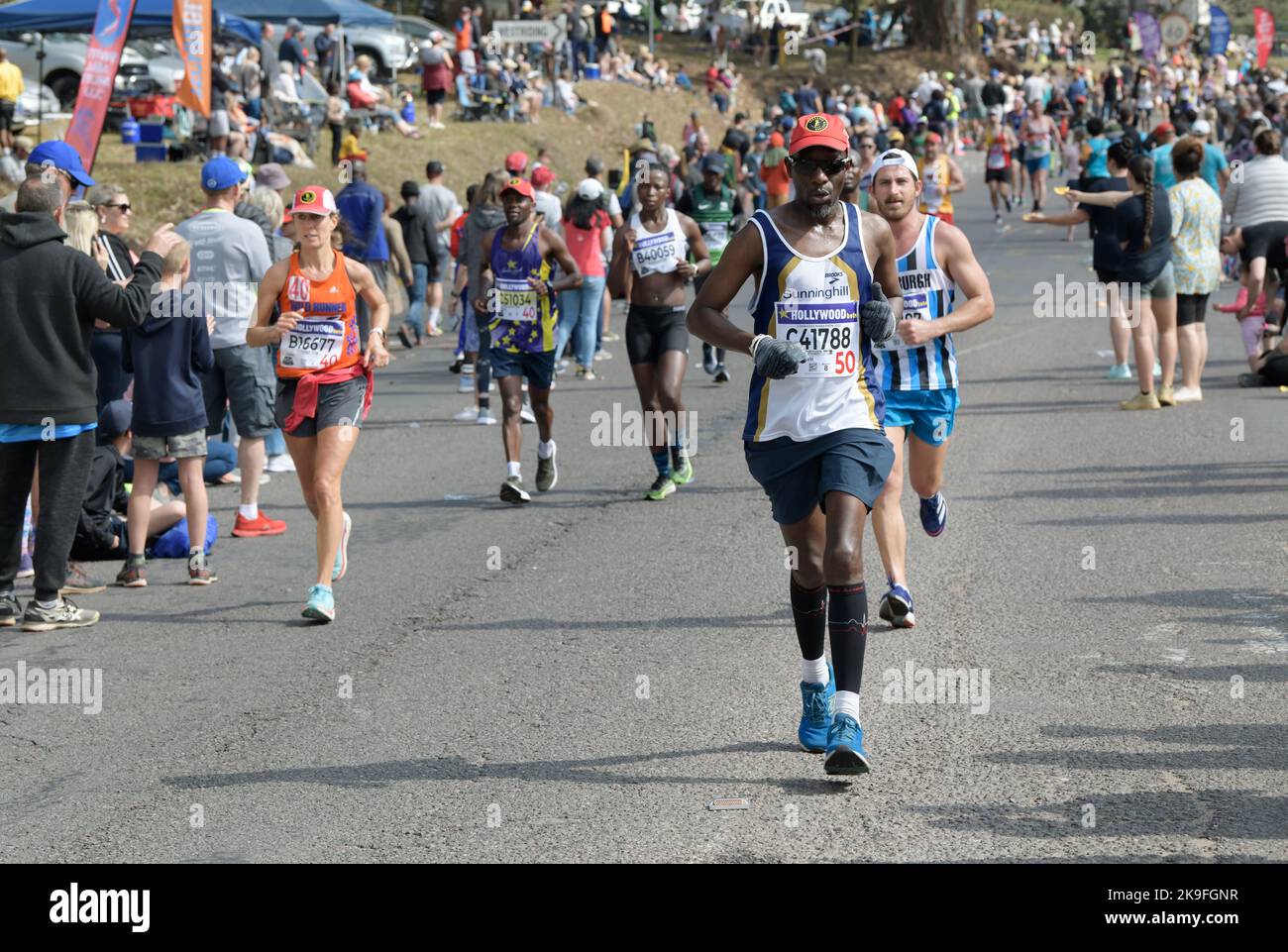 Fit adult man running with competitors past crowd, 95th Comrades Marathon 2022, ultimate human race, major sport event, Durban, South Africa, movement Stock Photo
