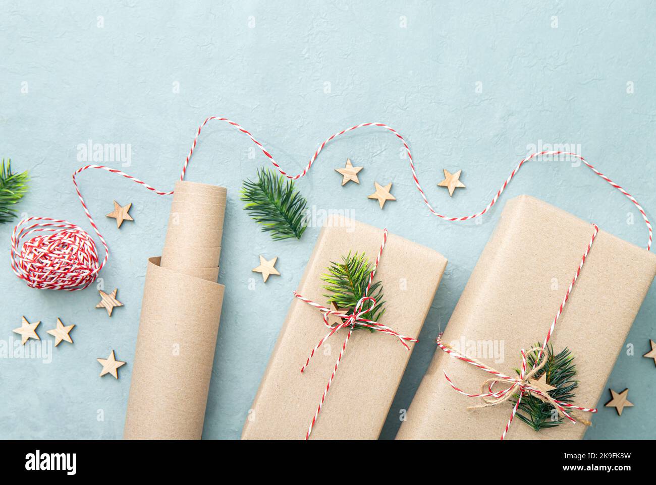 Gift wrapping with natural brown packing paper called Sack kraft paper or sack paper. Gifts decorated with red and white paper string. Stock Photo