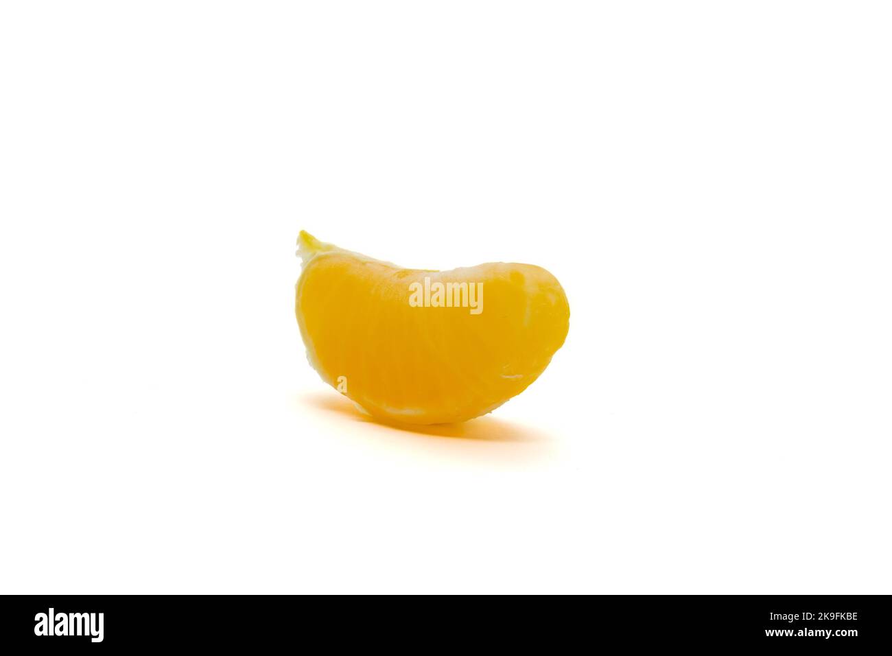 Single yellow slice of satsuma orange (Citrus unshiu) isolated on white