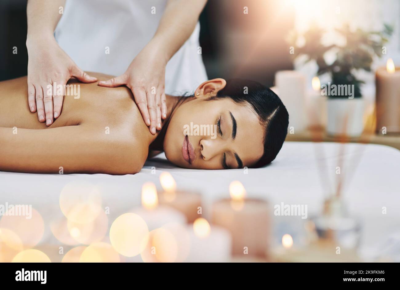 Getting rid of all the tension. a relaxed an cheerful young woman getting a massage indoors at a spa. Stock Photo