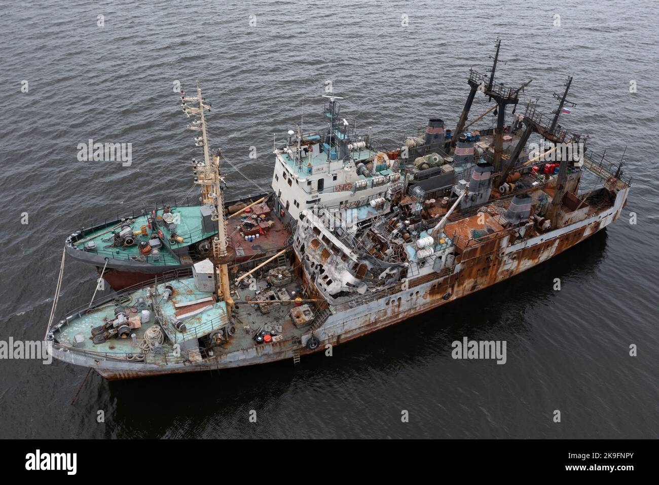 Vladivostok, Russia - July 23, 2022: The burnt fishing vessel on a mooring with other ship. Stock Photo