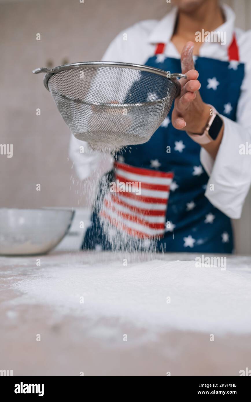 Woman sifting flour through sieve. Selective focus Stock Photo - Alamy