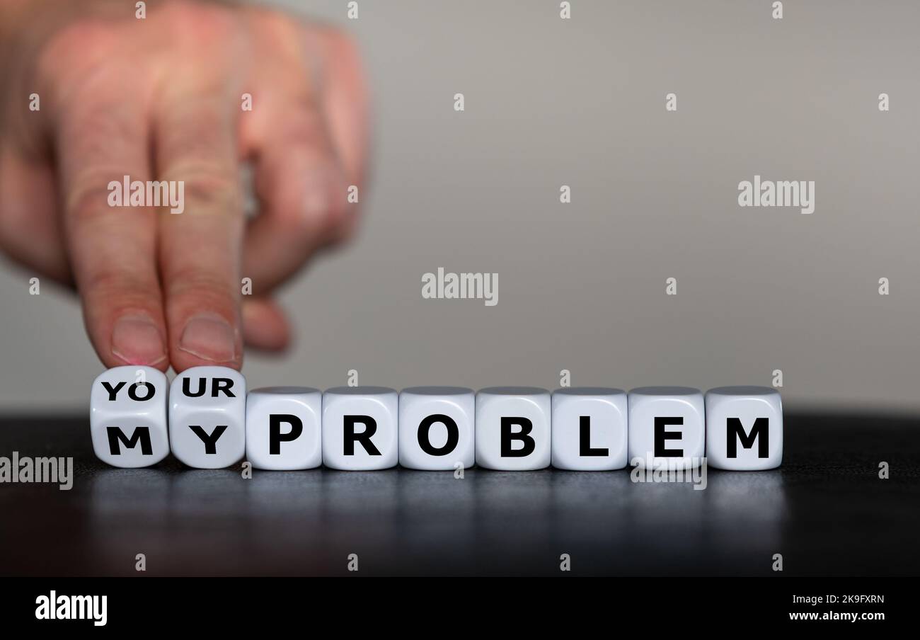 Hand turns dice and changes the expression 'my problem' to 'your problem'. Stock Photo