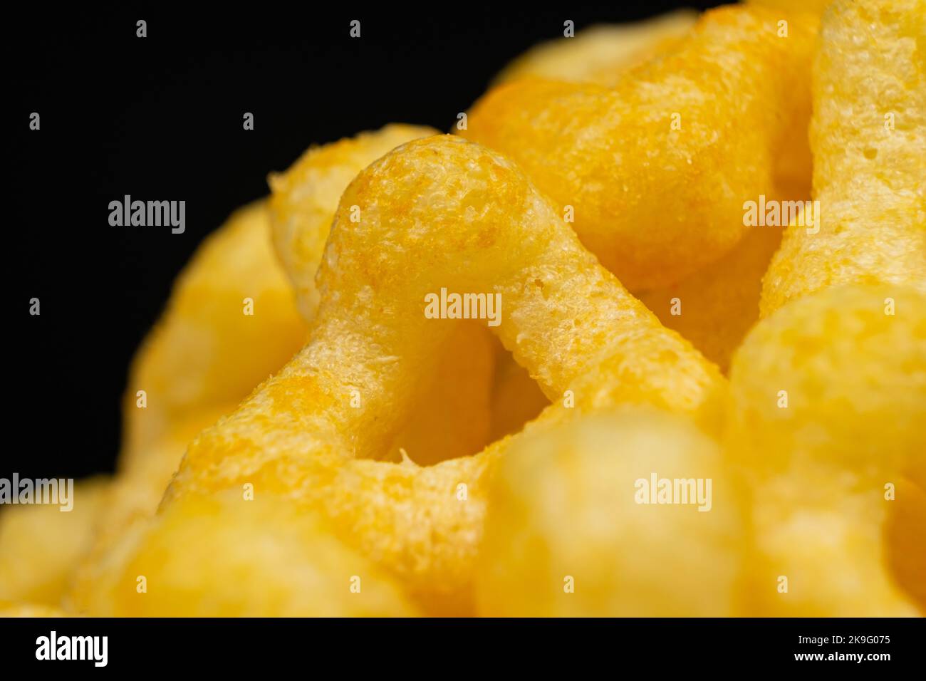 Delicious crispy corn chips with spices on a black background. Stock Photo