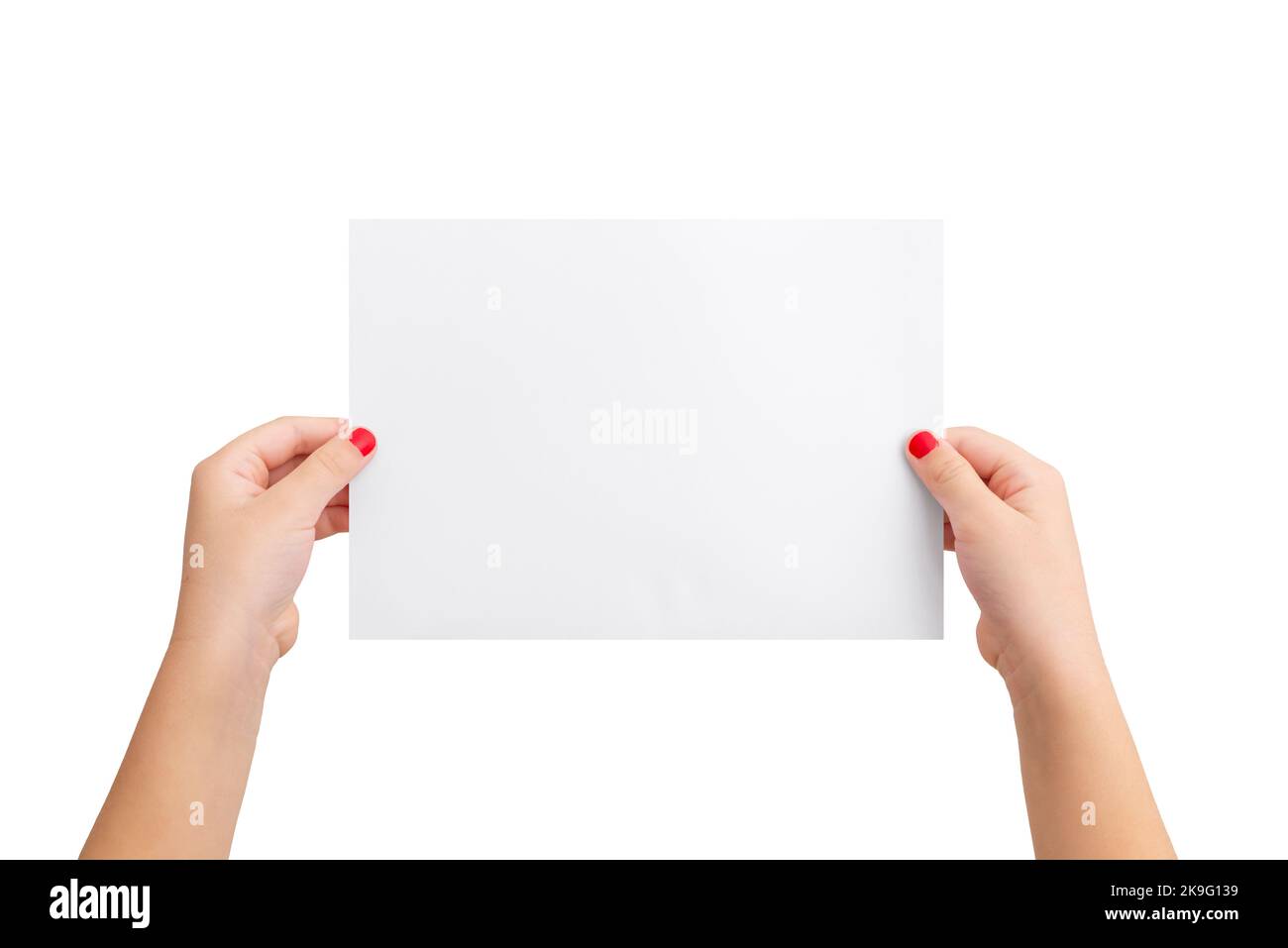 Girl's hands hold a blank paper in a horizontal position. Isolated background in white. Clean paper for copy presentation Stock Photo
