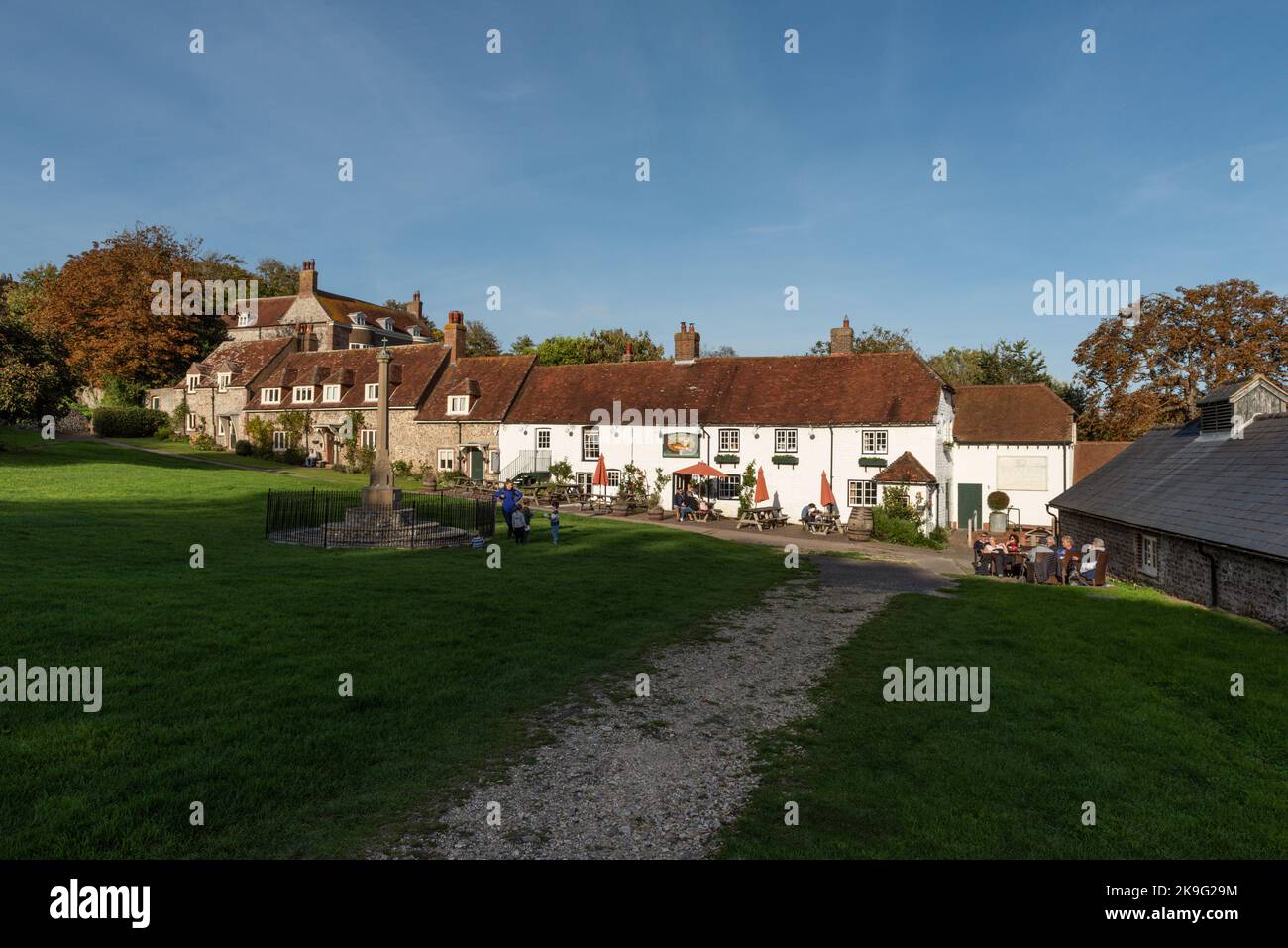 The Village Green at East Dean near Eastbourne, in East Sussex, England, UK, showing the Tiger Inn Public House in late afternoon autumn sunlight. Stock Photo