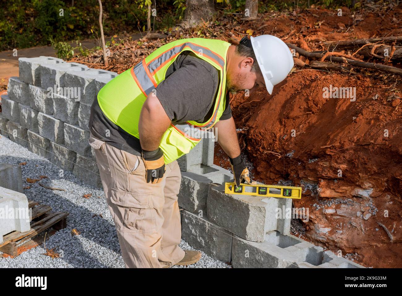 An installation of newly constructed large block retaining wall by contractor in construction
