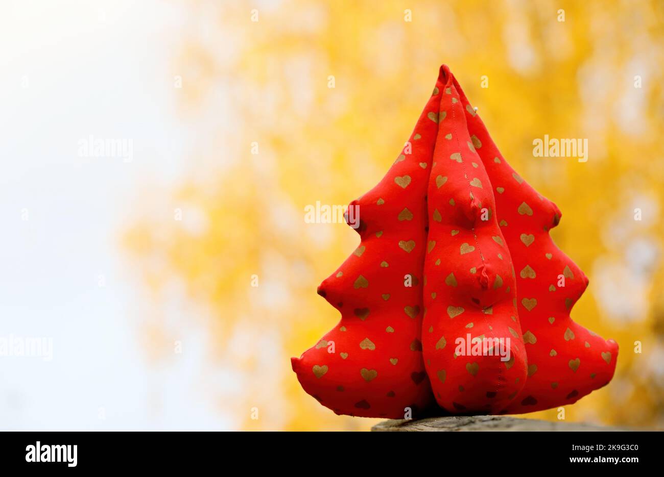 Red textile christmas tree with yellow background Stock Photo