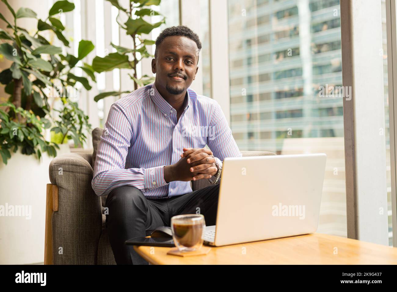 Portrait of handsome African businessman sitting in coffee shop Stock Photo
