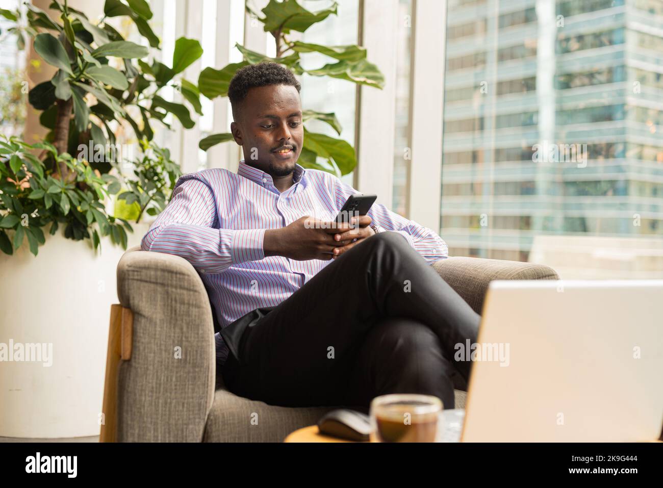 Portrait of handsome African businessman sitting in coffee shop Stock Photo