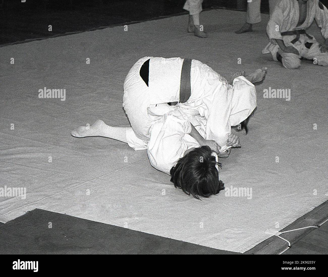 1970s, historical, inside, on a mat, two girls competing in the sport of judo, a physical activity that involves two people wrestling and trying to throw each other to the ground. Judo is a Japanese word meaning 'art of gentleness' and derives from the ancient Japanese martial art of jujitsu. Stock Photo