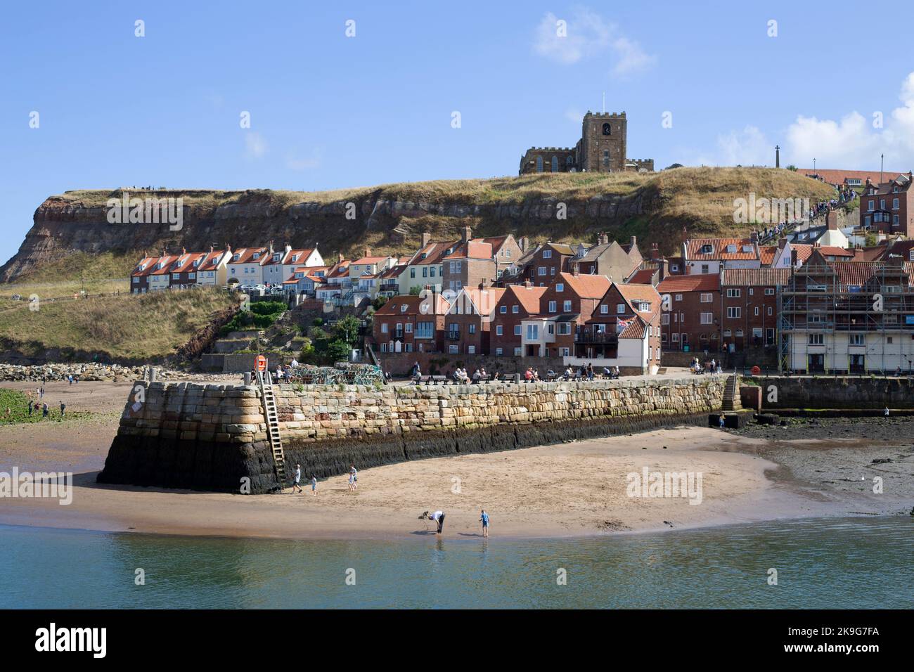 People “crabbing” on the pier in the seaside town of Whitby in North Yorkshire in Northern England. Stock Photo