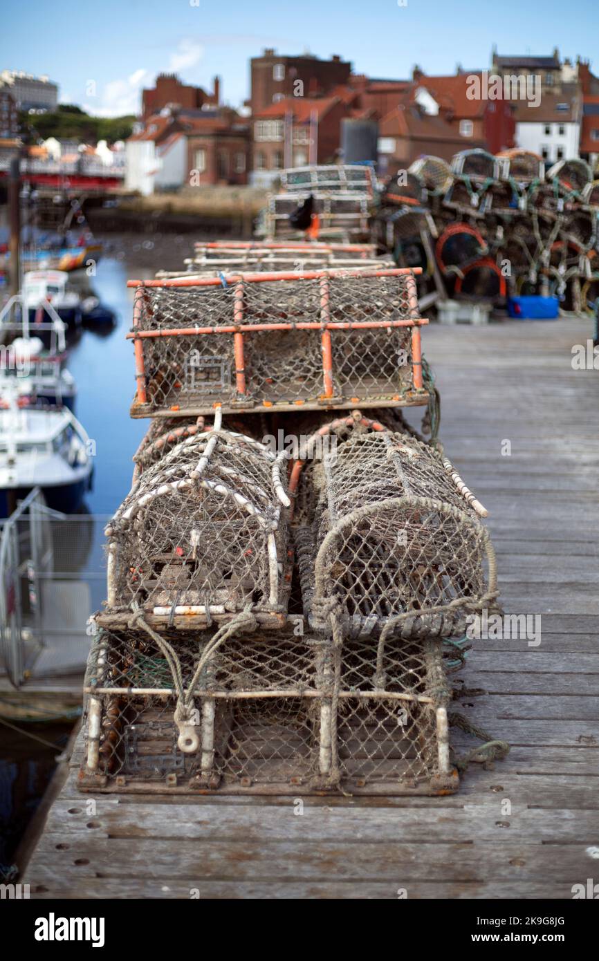 Lobster Pots on the pier in the seaside town of Whitby in North Yorkshire in Northern England. local fisherman and the community have suffered in the Stock Photo