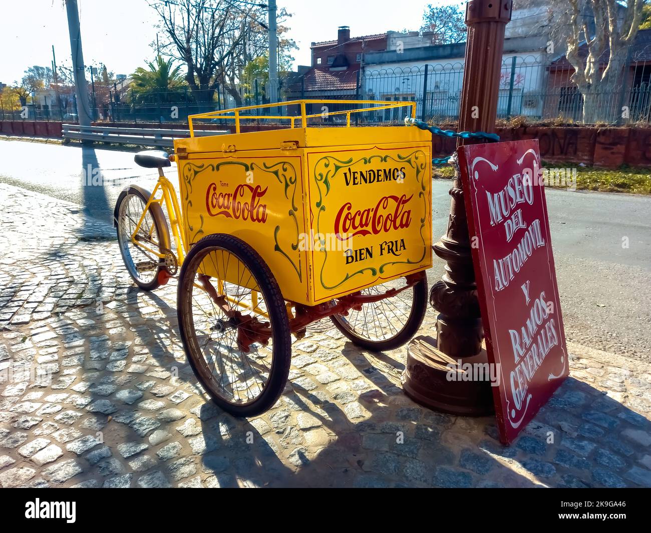 Old fresh beverage vending cargo bike on the cobblestone. Delivery trike. Drink Coca Cola logo and brand with traditional fileteado ornaments. Stock Photo
