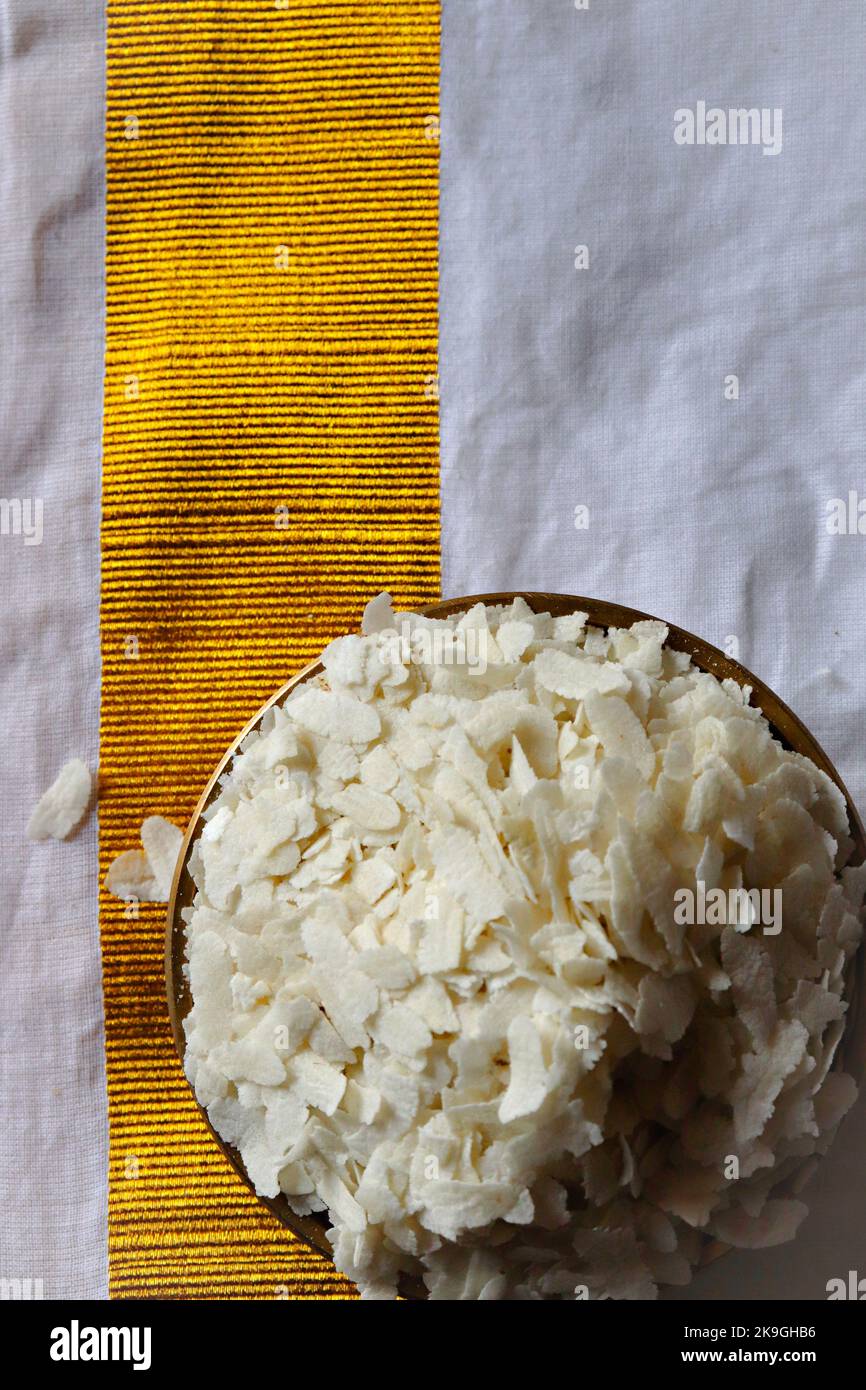 Close-up of  raw poha/beaten rice/flattened rice in a brass Uruli/vessel Stock Photo