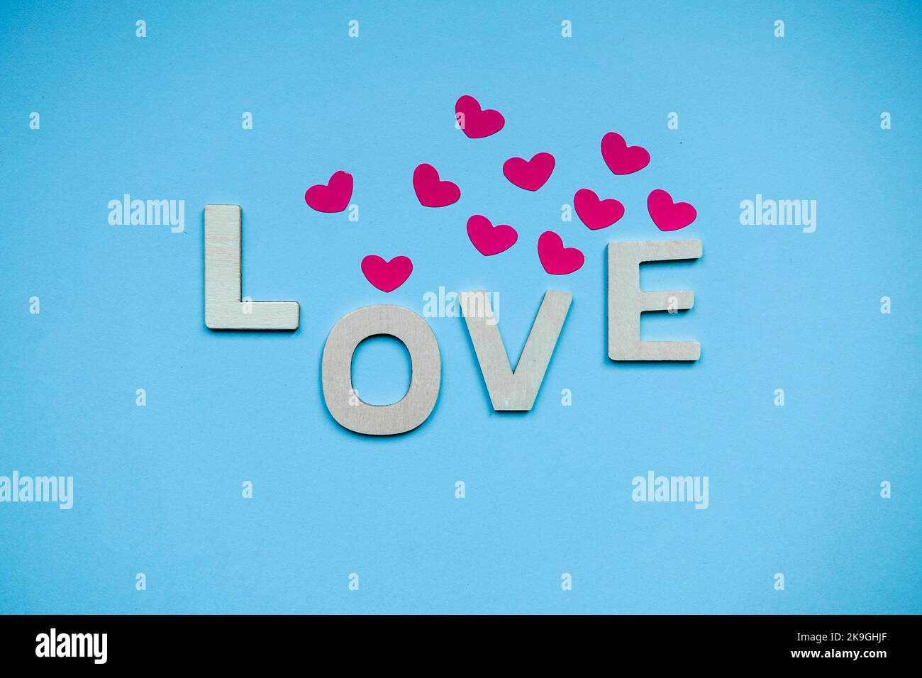 love wooden letters and heart shapes on the blue background for ...