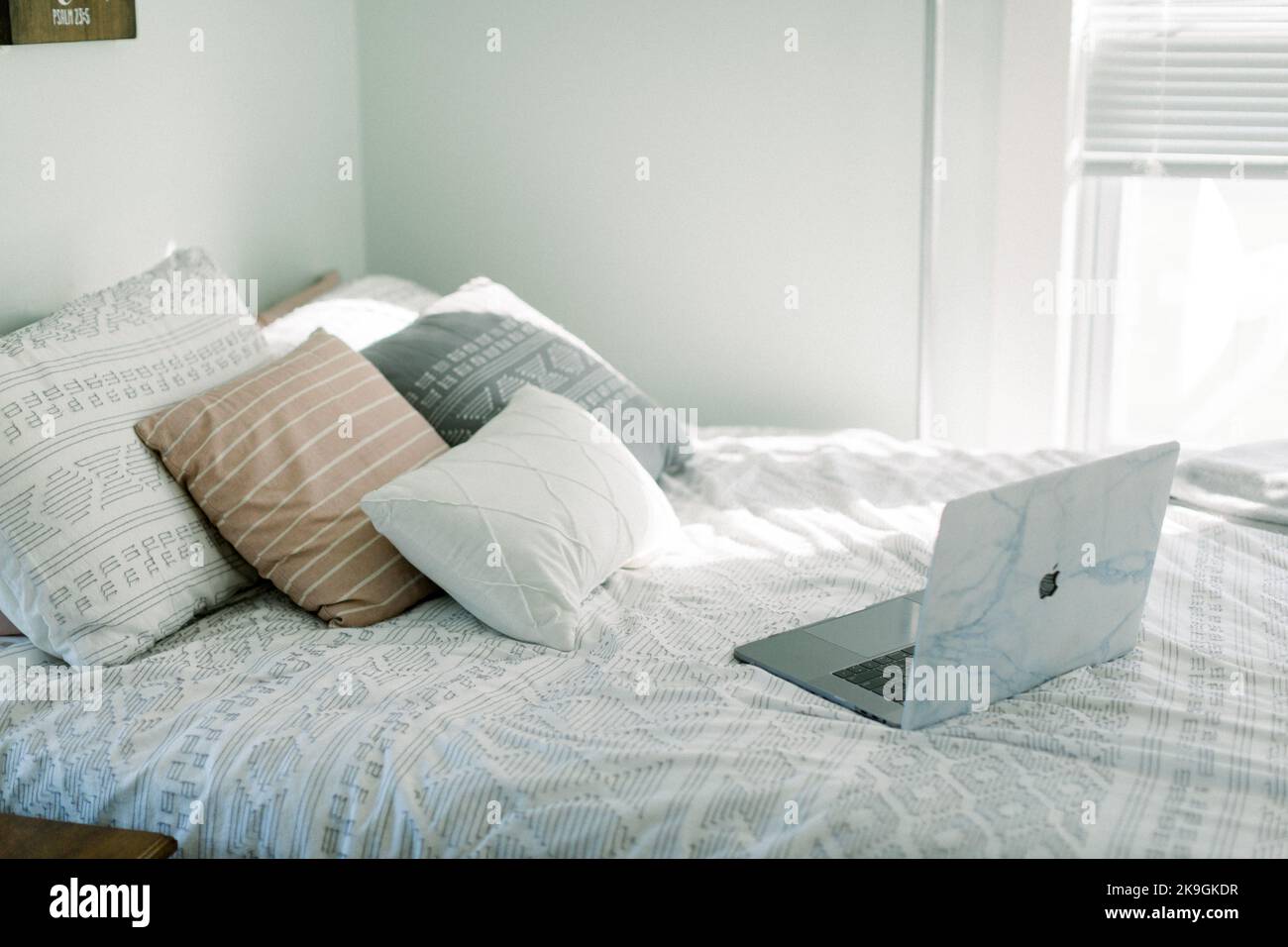 MacBook Pro with marble case sitting in stylish farmhouse bedroom Stock Photo