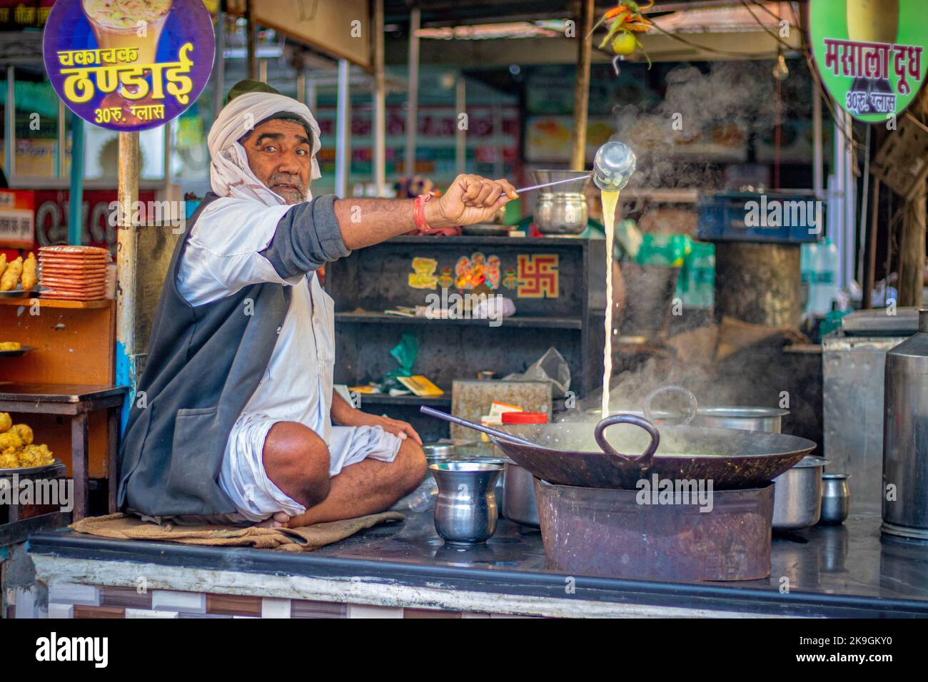An old man making masala doodh in his shop in Nathdwara, India. Stock Photo
