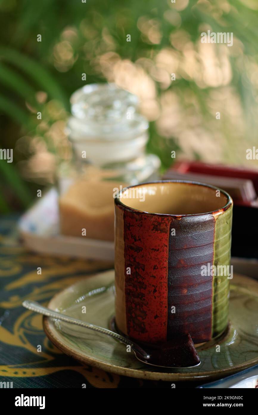 Vertical shot of a colorful handmade boho style ceramic cup Stock Photo