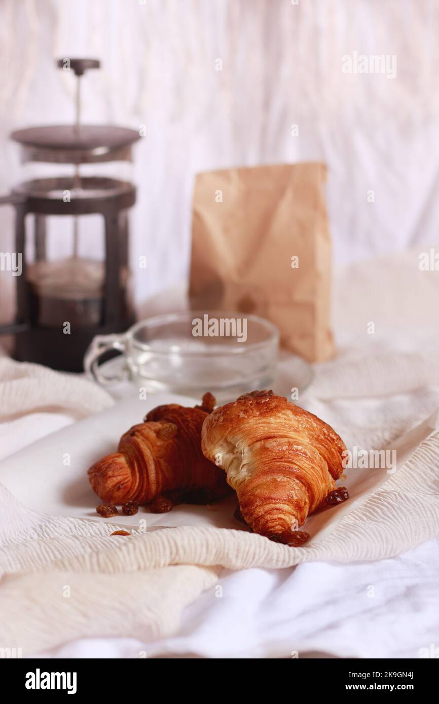 Two freshly baked croissants paired with french press coffee Stock Photo