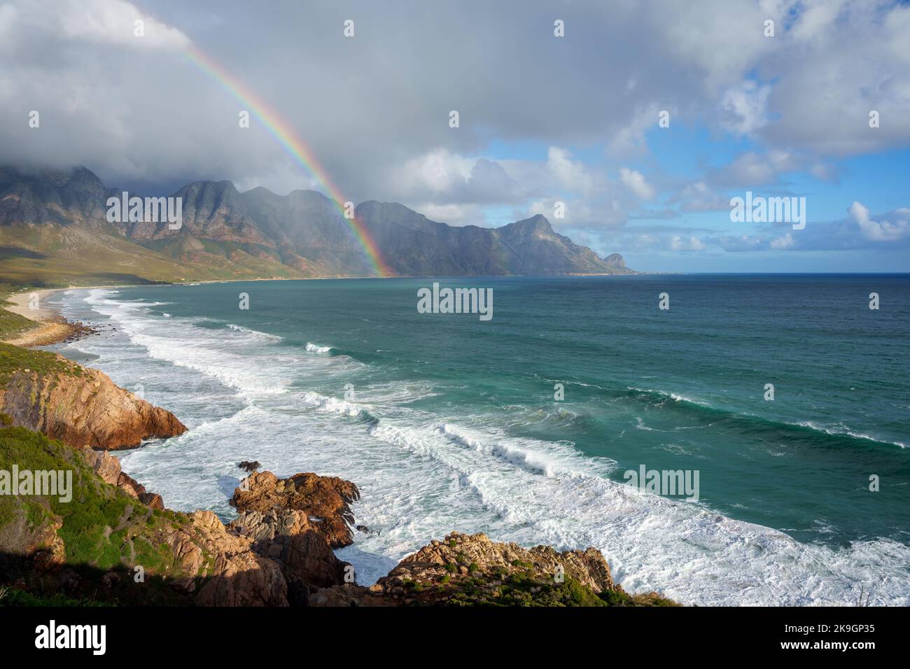 View with rainbow towards Rooi Els and Hanklip from Clarence Drive on the eastern side of False Bay. Cape Town, Western Cape, South Africa. Stock Photo