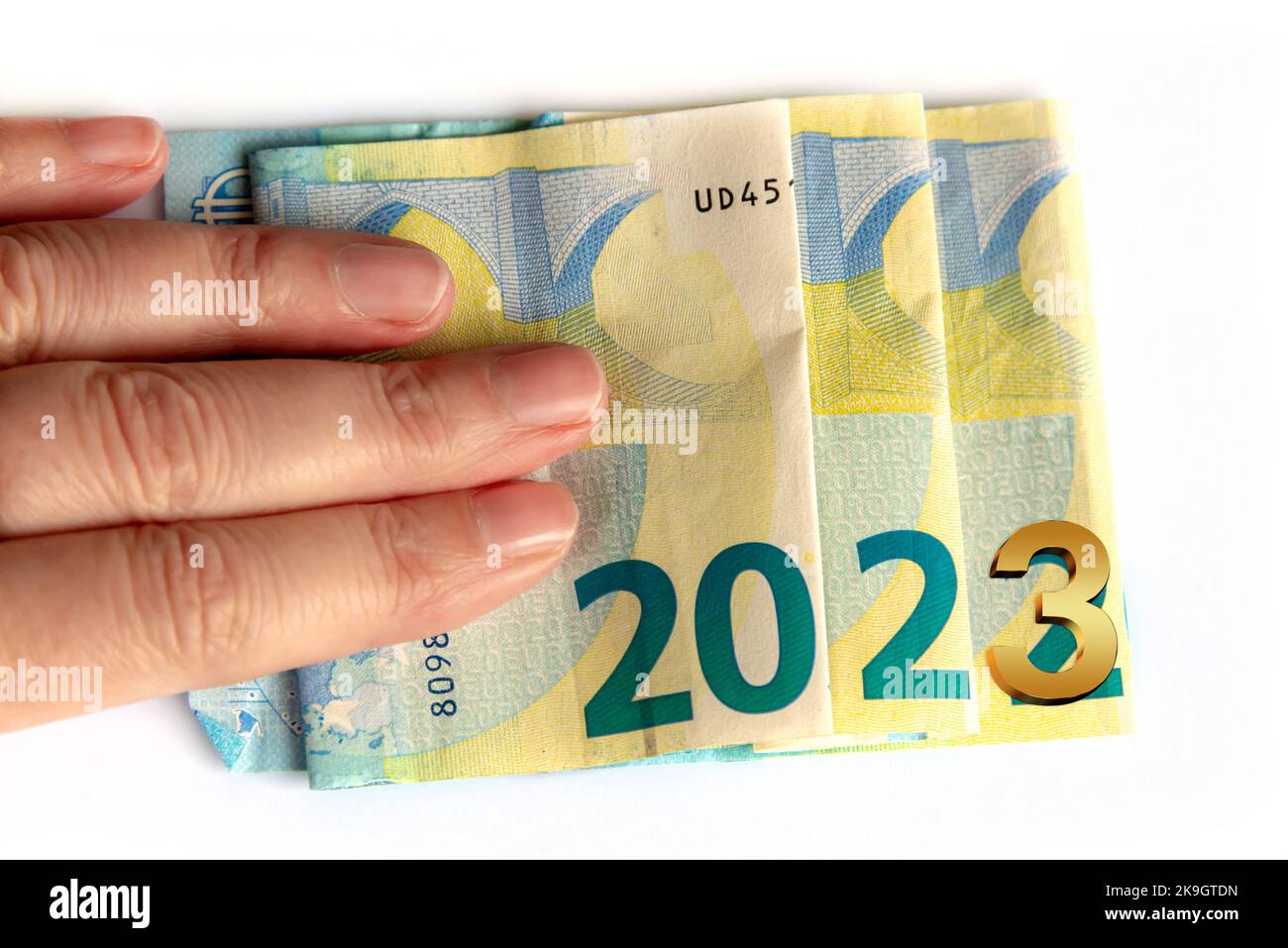 2023 written with euros bank notes in a hand isolated on white ...