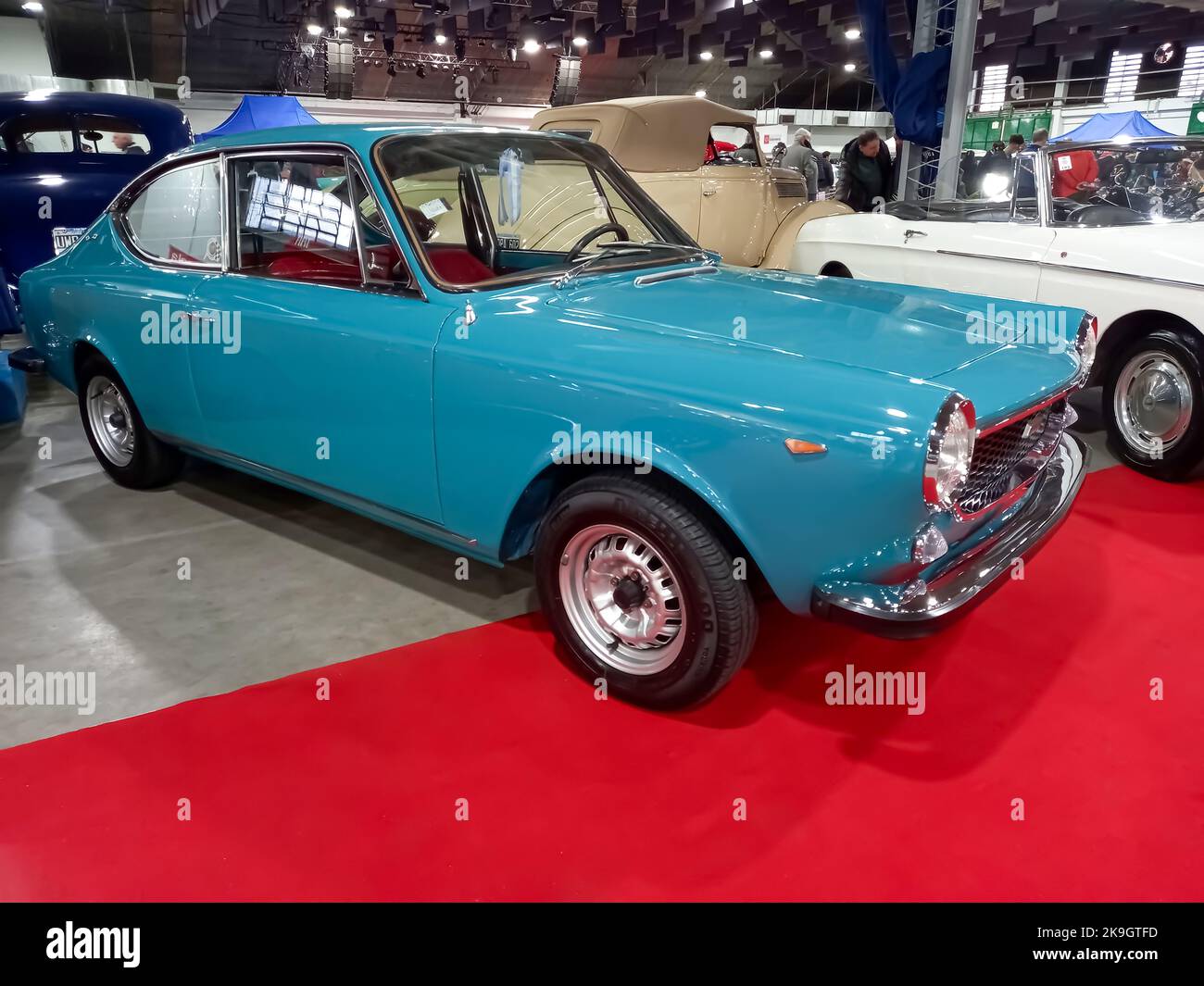 Old aqua blue 1972 Fiat 125 Sport coupe fastback berlinetta on the red carpet. Exhibit hall. Classic car show. Copyspace Stock Photo