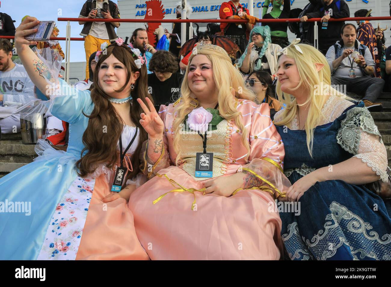 London, UK. 28th Oct, 2022. (left to right) Queen Erika and Princess Anneliese from the Barbie movie take selfies with and original character creation outside the ExCel Centre. Cosplayers, fans of anime, films and other visitors, most of them in costume, enjoy the opening day of MCM Comic Con at Excel London. Credit: Imageplotter/Alamy Live News Stock Photo