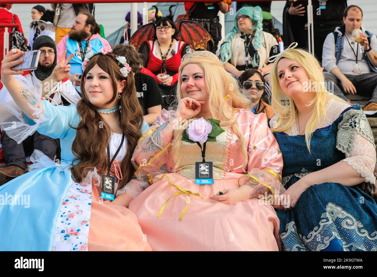 London, UK. 28th Oct, 2022. (left to right) Queen Erika and Princess Anneliese from the Barbie movie take selfies with and original character creation outside the ExCel Centre. Cosplayers, fans of anime, films and other visitors, most of them in costume, enjoy the opening day of MCM Comic Con at Excel London. Credit: Imageplotter/Alamy Live News Stock Photo