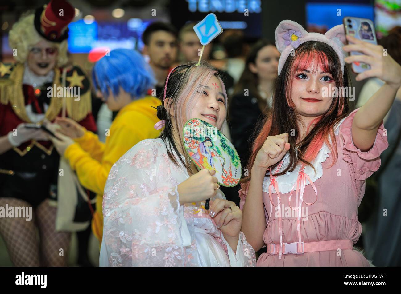 London, UK. 28th Oct, 2022. A visitor as Lina Bell, a Disneyland character, takes selfies with her friend dressed in Geisha outfit. Cosplayers, fans of anime, films and other visitors, most of them in costume, enjoy the opening day of MCM Comic Con at Excel London. Credit: Imageplotter/Alamy Live News Stock Photo