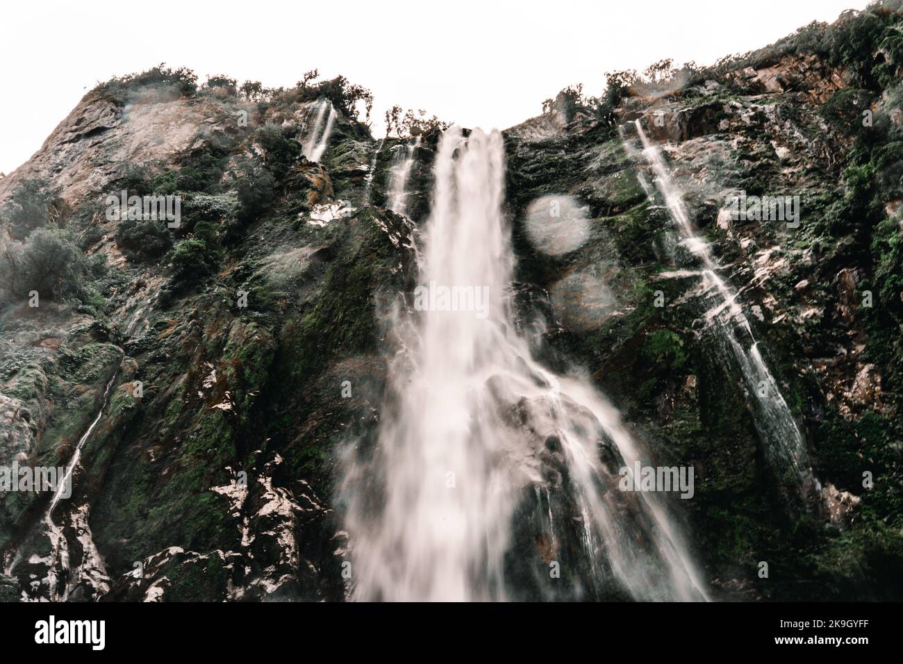 large cascades of water rushing down the rocky mountains splashing on ...