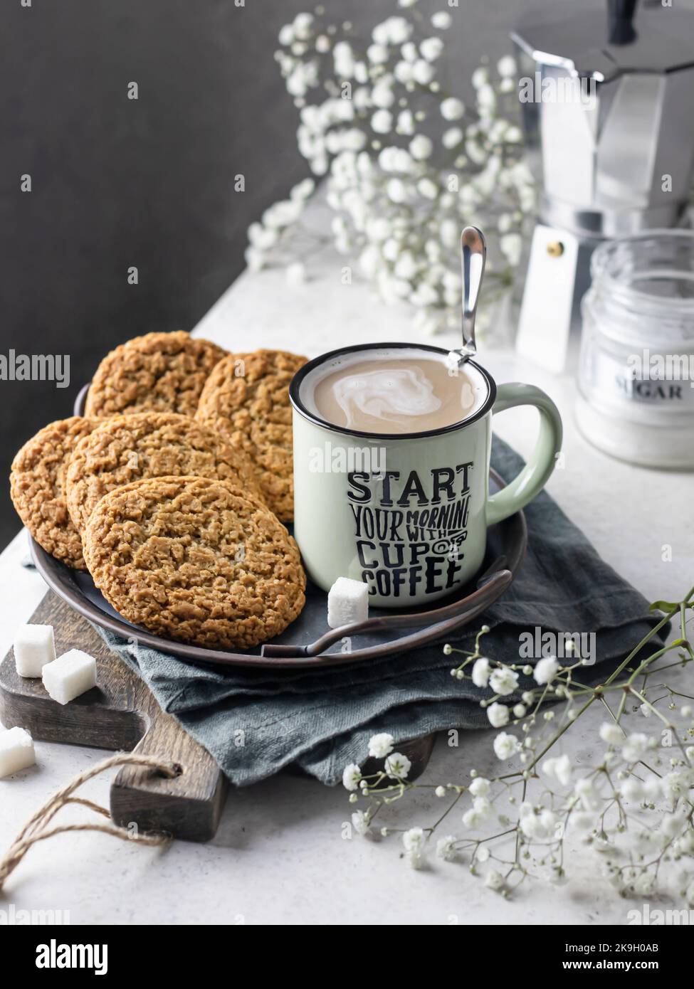 Mug of hot coffee with homemade oatmeal cookies on a rustic metal tray. Home warmth and comfort in autumn morning concept. Autumn still life Stock Photo