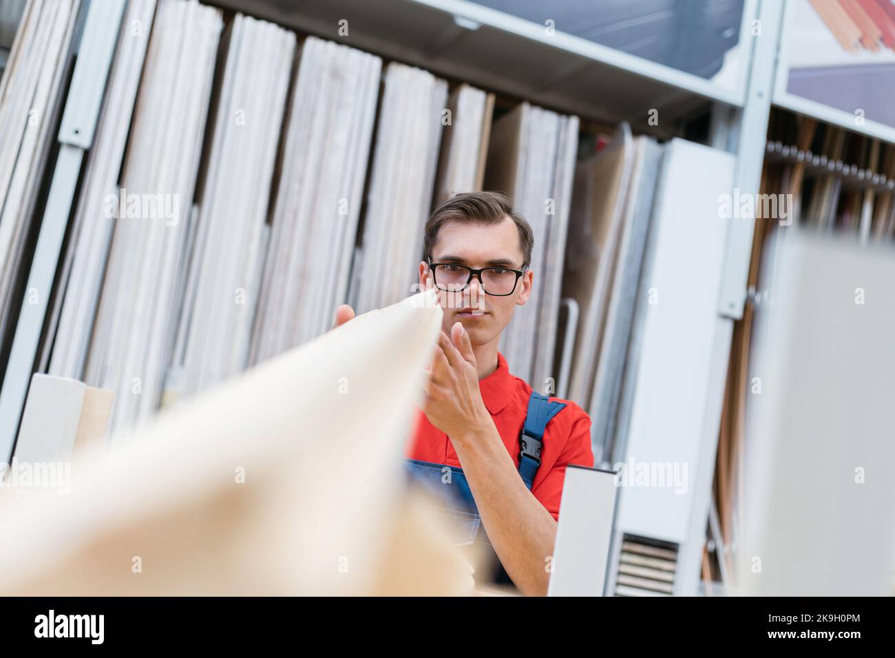 seller of the floor coverings store choosing the necessary samples of