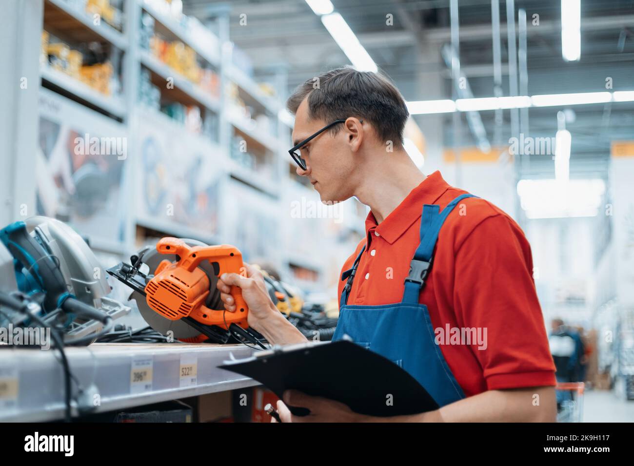 supervisor of the hardware store checking the markings on the power tools. Stock Photo