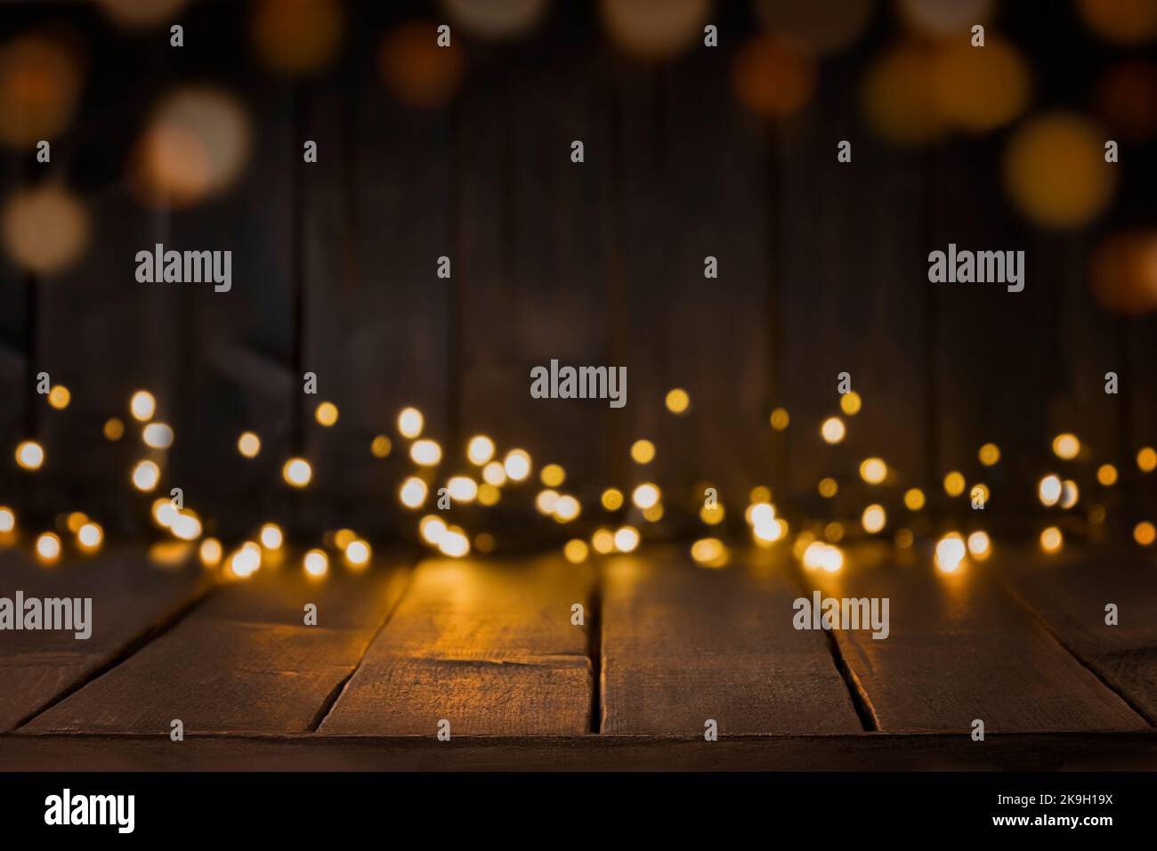 Festive background of dark brown table top with lights bokeh. Copy space, space for products display Stock Photo