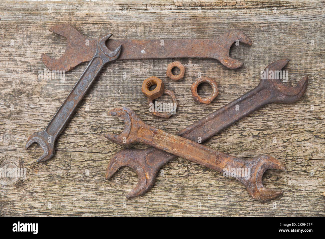 rusty wrenches and nuts on old unpainted boards Stock Photo