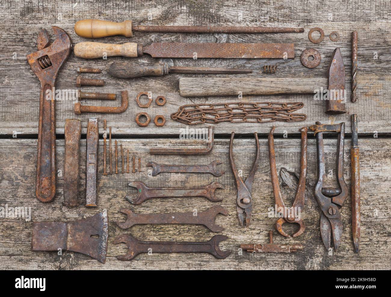 rusty tools lie on old wooden table Stock Photo