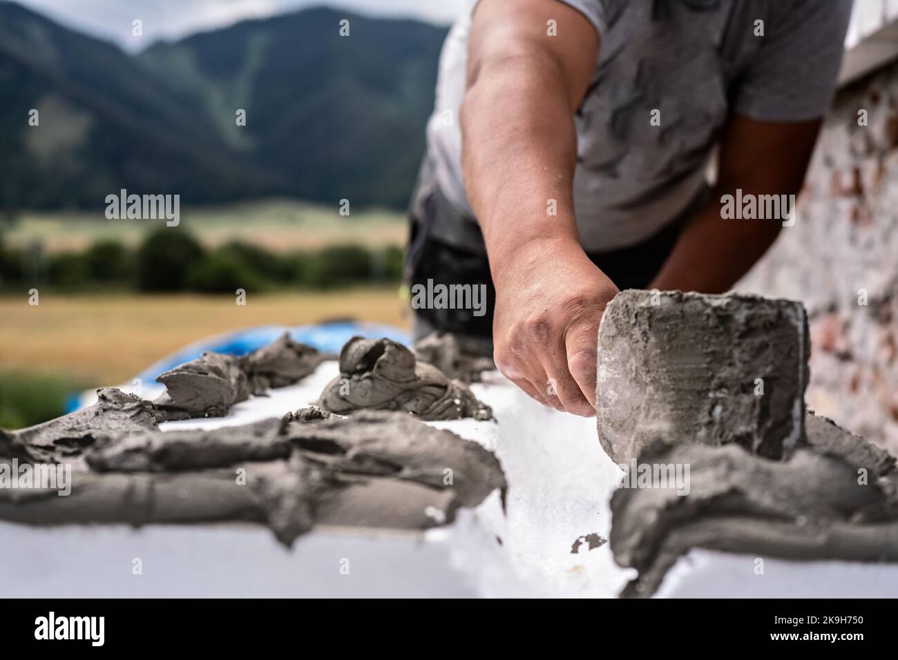 Installing white polystyrene heat insulation, detail on worker hand