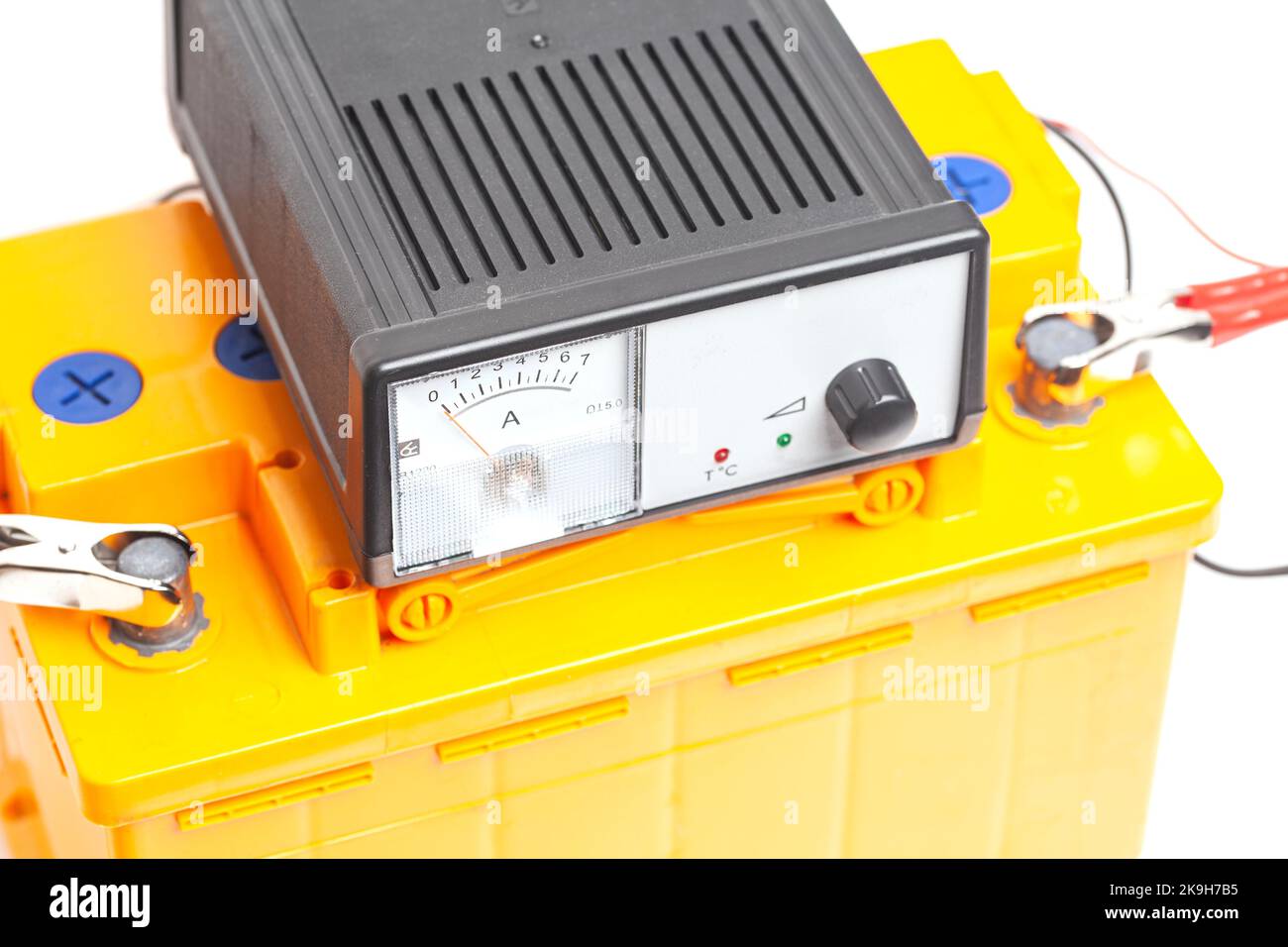 yellow car battery with car battery charger isolated on white