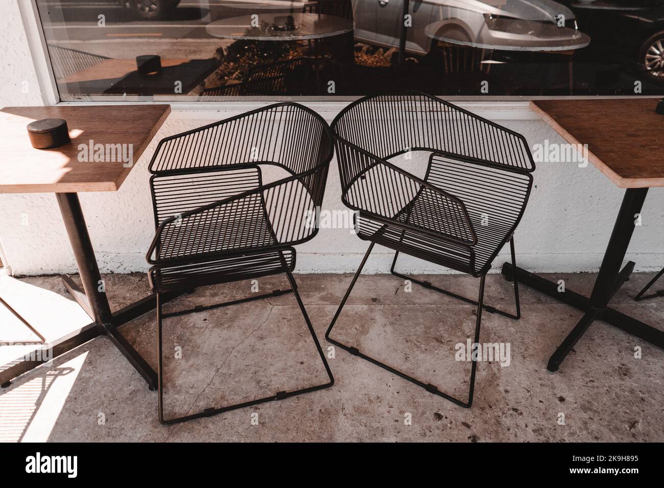 original metal wire chairs and wooden tables outside a quiet coffee