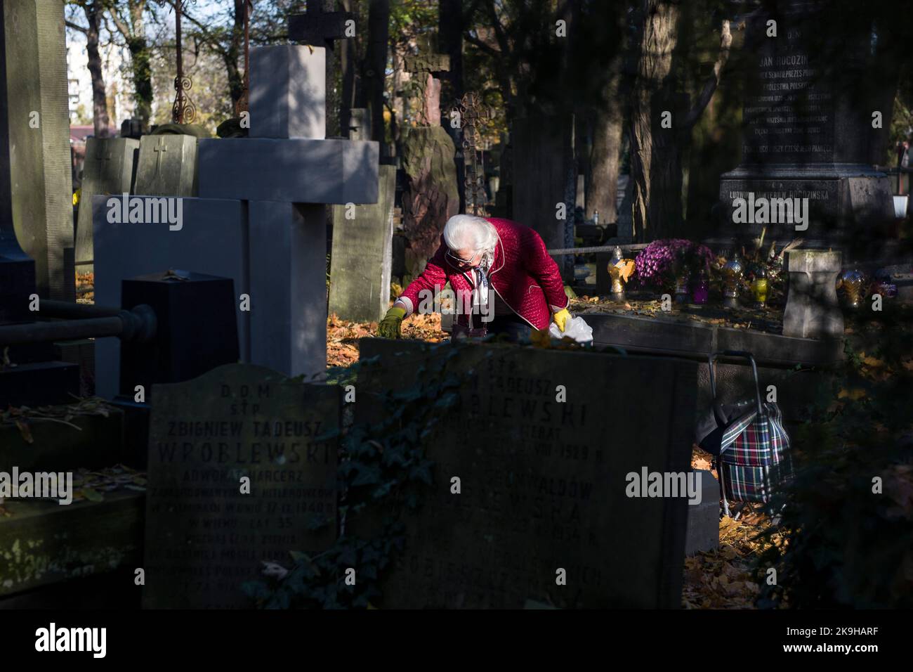 An elderly woman seen cleaning a grave at the historic powazki cemetery